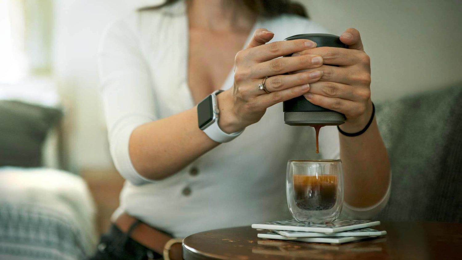 Wacaco Picopresso portable espresso maker pulling a shot of espresso, a luxury travel gift for coffee lovers.